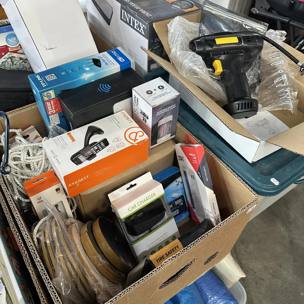 Box lot of assorted new products including modem routers, phone car mount and charger, weather strip, compressor and bin Image 1++