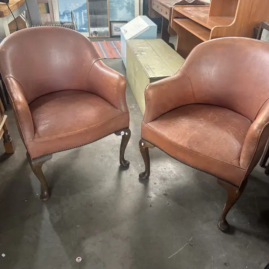 Pr of distressed leather and domed tub chairs