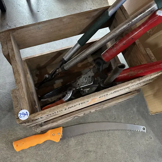 Beer crate with garden loppers, hedge clippers and branch saw etc.
