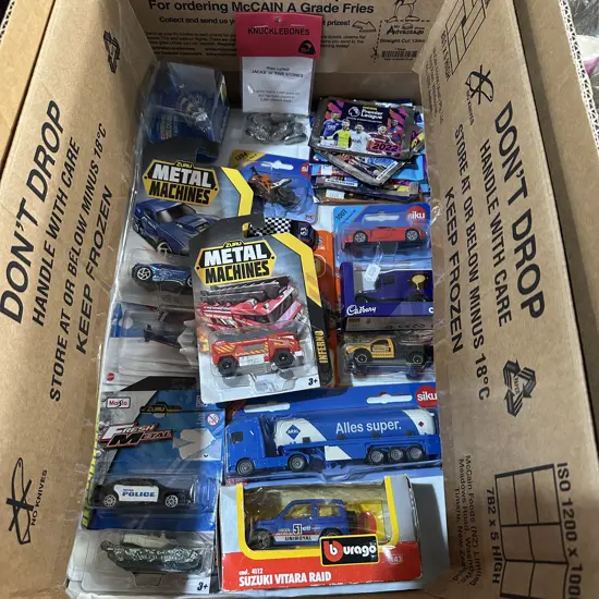Collection of boxed toy cars and trucks, knucklebones, football stickers etc.