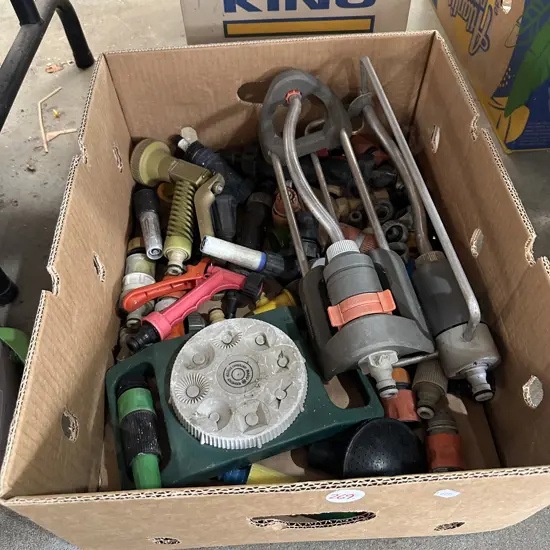 Box of garden hose attachments and sprinklers.