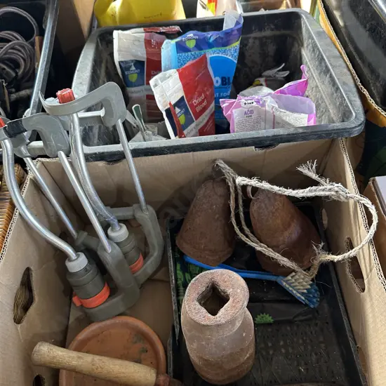 Bin of plant food and fertilizers plus a box of sprinklers, steel bells etc.
