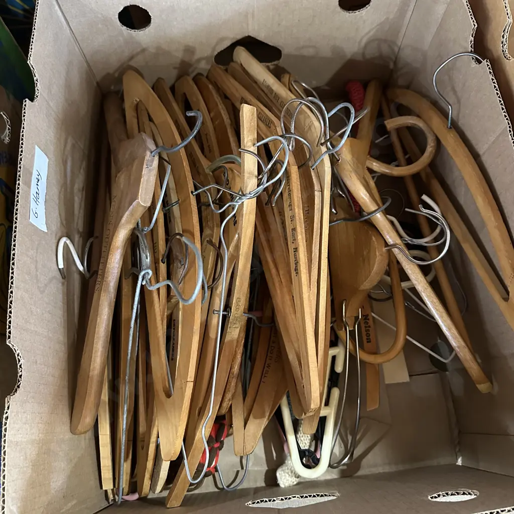 Box lot of assorted coat hangers including wooden. Image 1++
