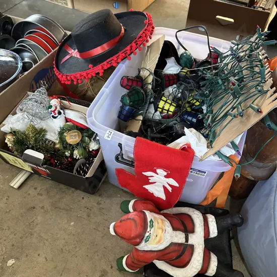 Bin full of christmas decorations, lights, hats and a chrstmas tree etc.