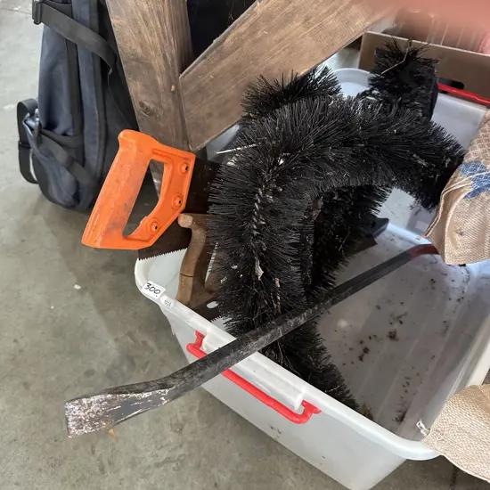 Plastic bin with saws, pinch bar and gutter bristles.