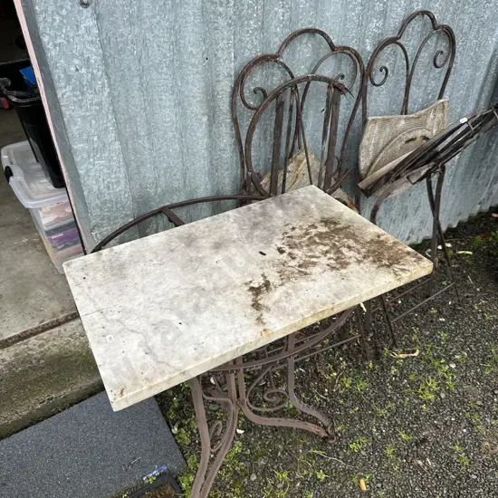 slab of marble and broken/rusty outdoor garden suite