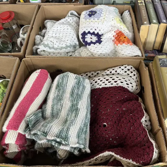 Two boxes of blankets and crochet blankets.