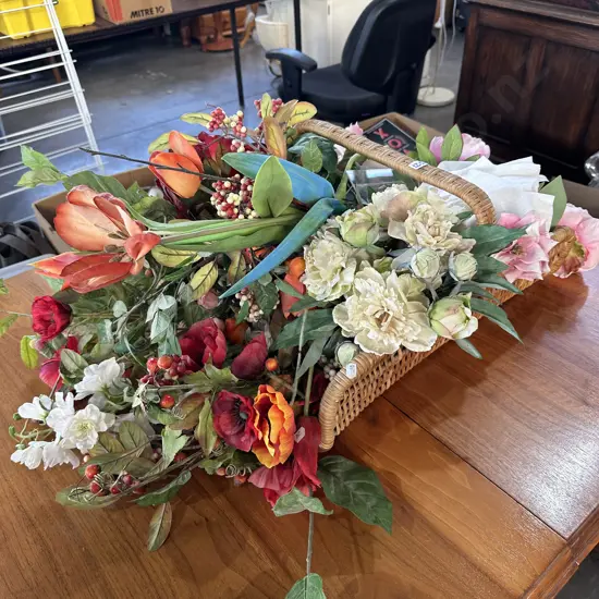 Wicker basket filled with artificial flowers.