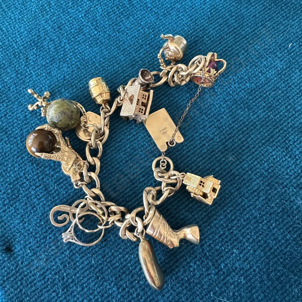9ct Gold vintage charm bracelet includes 13 charms & 2 rings, total weight 47.4g Image 1++