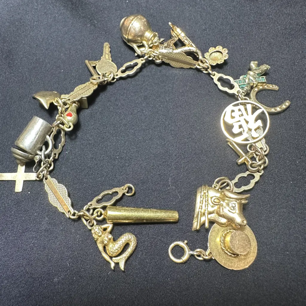 Charm bracelet with a variety of gold and other charms Image 1++