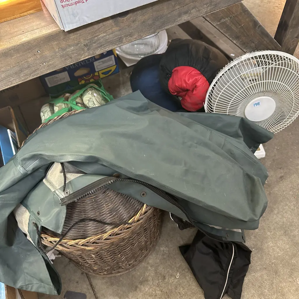 Bay lot of sleeping bags, cane baskets, wet weather gear and fan. Image 1++